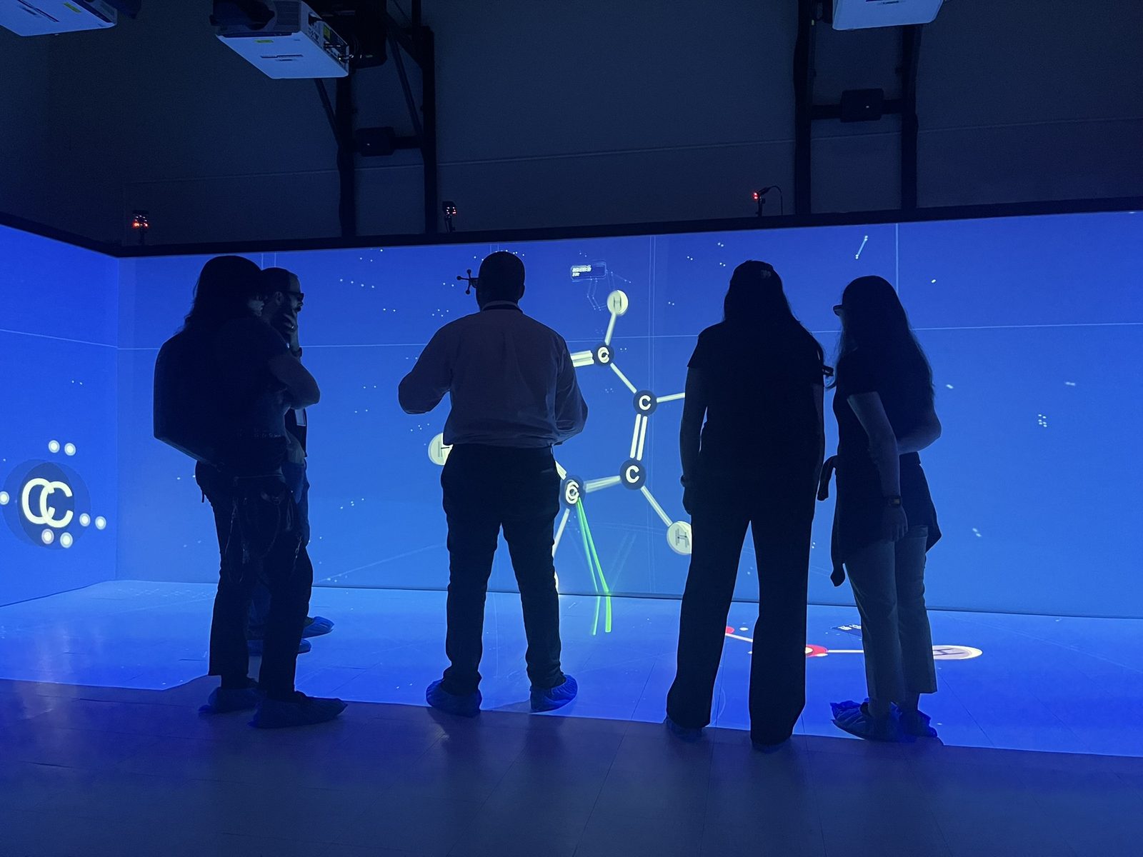 Visitors studying a molecule in the CAVE