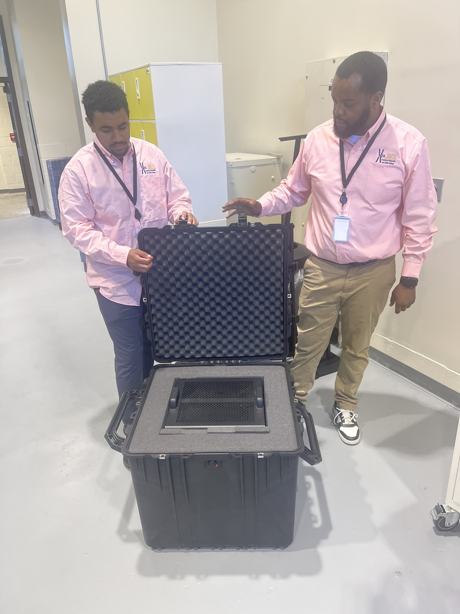 Two team members opening a rugged travel case with studio gear